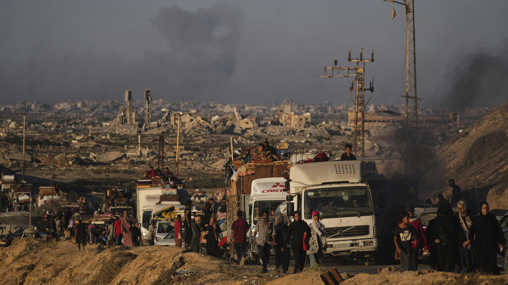 Displaced Palestinians fleeing northern Gaza carry their belongings along the coastal road toward southern Gaza, Saturday, Sept. 13, 2025, after the Israeli army issued evacuation orders from Gaza Cit