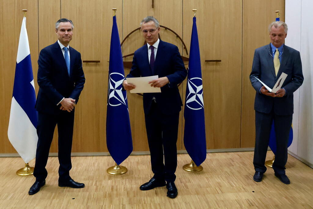 Os embaixadores da Finlândia (à esquerda) e da Suécia (à direita) na aliança militar ocidental entregam as respectivas propostas de adesão ao secretário-geral da OTAN, Jens Stoltenberg (centro), na sede da organização em Bruxelas, em 18 de maio de 2022.