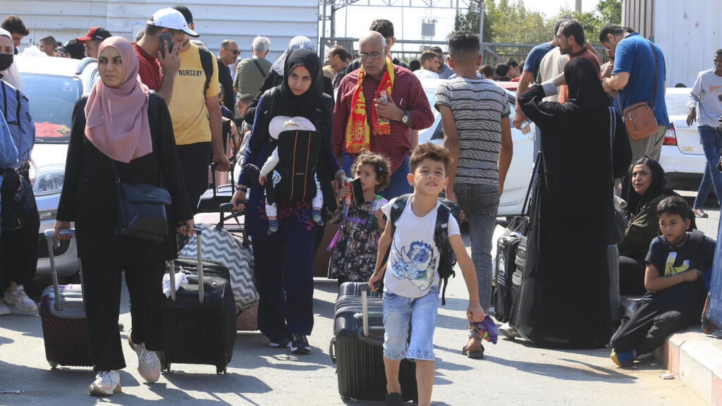 Des Palestiniens attendent au poste frontière de Rafah entre la bande de Gaza et l'Égypte, samedi 14 octobre 2023.