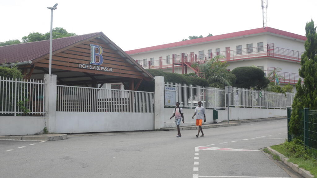 Des personnes passent devant les grilles fermées du Lycée français Blaise Pascal à Libreville, le 16 mars 2020. (Photo d'illustration)