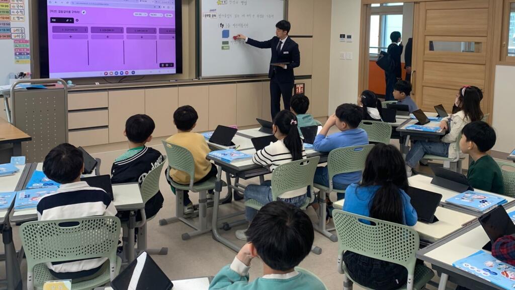 Une Classe de CE2 en cours de mathématique, les élèves suivent le cours sur leurs tablettes, à Daegu en mai 2025.