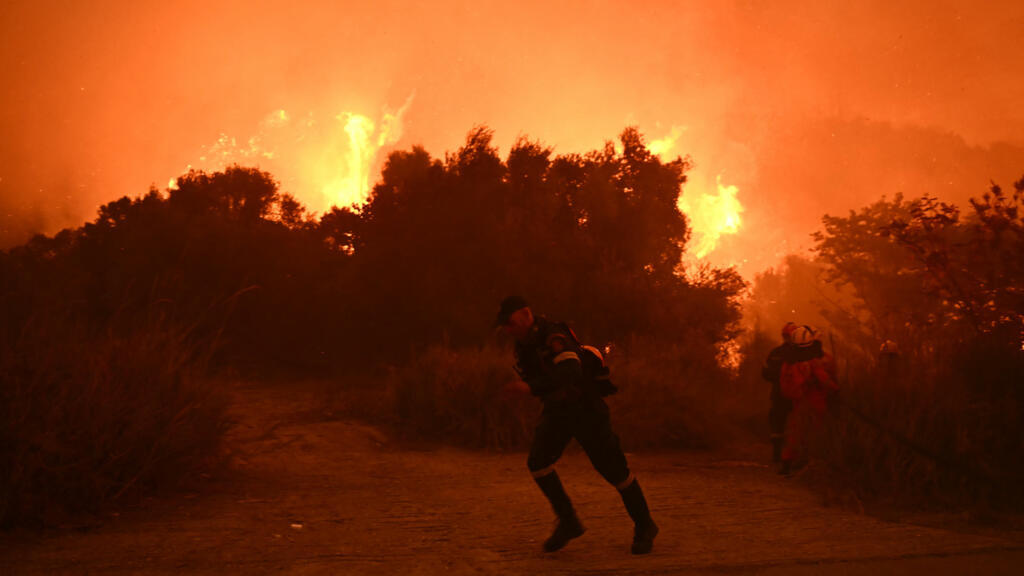 Les pompiers s'efforcent d'éteindre un incendie de forêt près de la ville de Patras, dans l'ouest de la Grèce, le 13 août 2025.