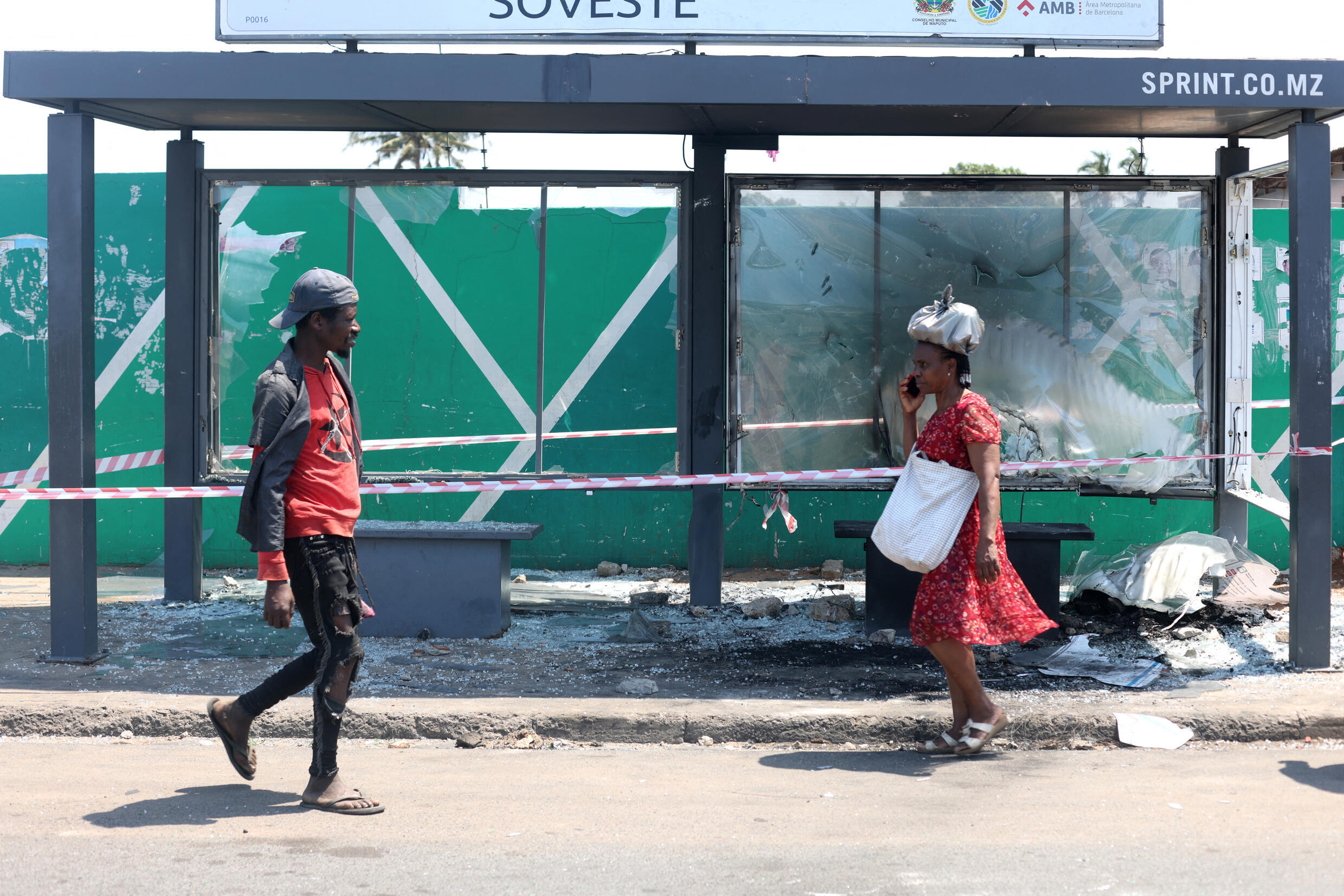 Wakazi wakipita kituo cha mabasi kilichoharibiwa huko Maputo, mji mkuu wa Msumbiji, Oktoba 25, 2024.