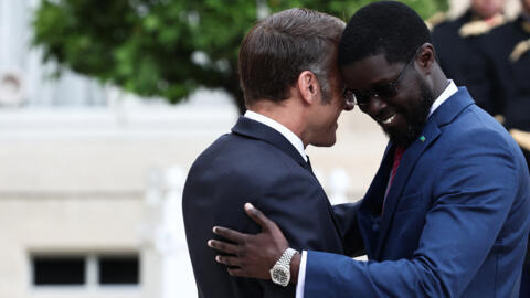Frencg President Emmanuel Macron hugs Senegalese President Bassirou Diomaye Faye as they arrive for a meeting at the Elysée Palace in Paris on 27 August 2025.