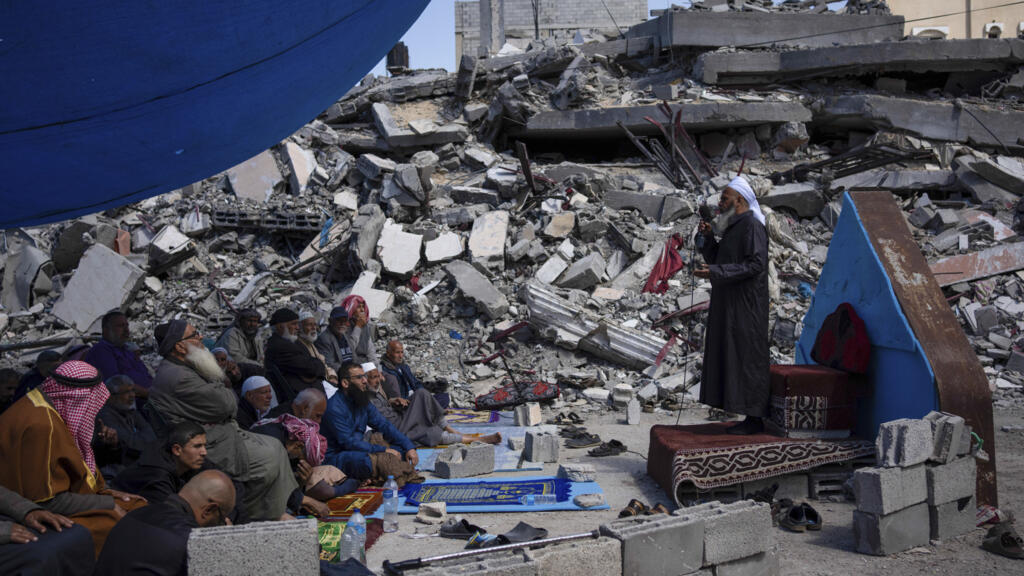 Des Palestiniens prient devant une mosquée détruite par les frappes aériennes israéliennes à Rafah, dans la bande de Gaza, le vendredi 8 mars 2024, à l'approche du mois sacré islamique du Ramadan.