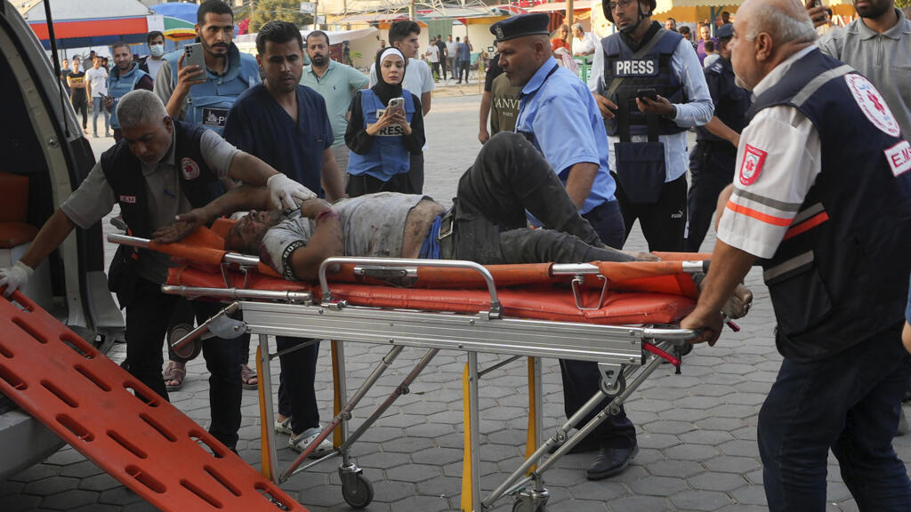 Des journalistes assistent à l'évacuation d'un blessé par les secours, dans la bande de Gaza, le 16 octobre 2023.