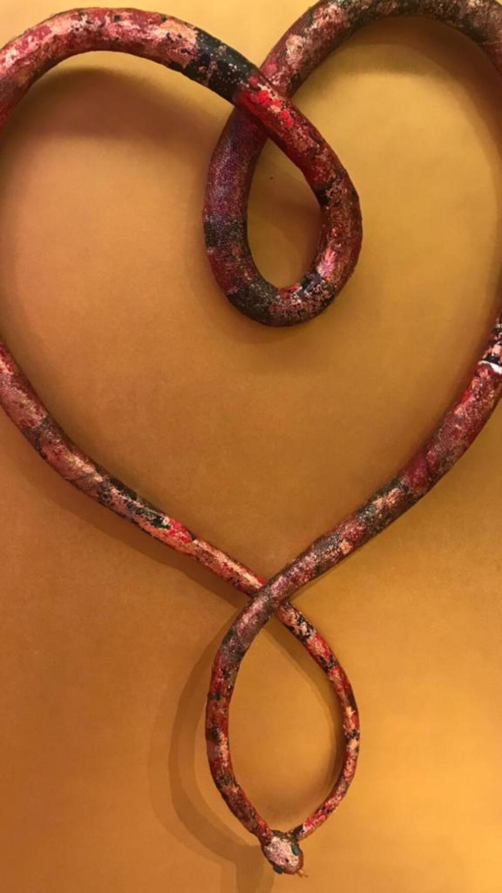 Uma das obras em exposição em Genebra - escultura em papel machê de uma grande cobra que forma um coração.