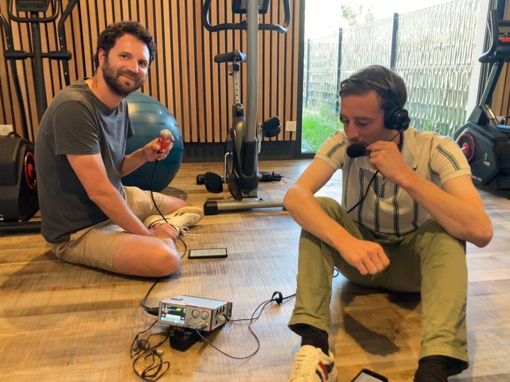 Alexis Bedu et Thomas de Saint Leger pendant l'enregistrement du podcast Témoins d'actu sur la route de la course cycliste du Tour de France, le 11 juillet 2022.