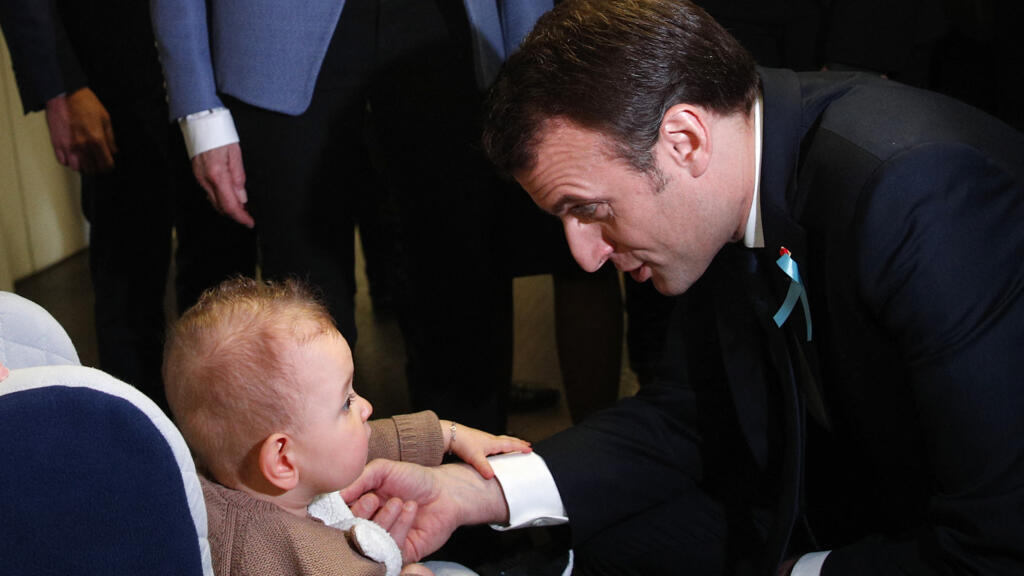 O presidente francês, Emmanuel Macron, brinca com um bebê durante uma visita ao hospital de Rouen, no norte da França, em 5 de abril de 2018.