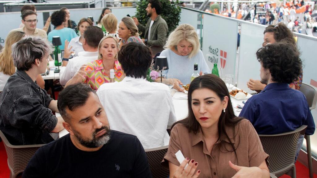 Le policier Tahir Idiskut (à gauche) et l'enseignant Ilkay Idiskut (à droite) participent à l'événement «L'Autriche des tables rondes et carrées» (Oesterreich der runden und eckigen Tische), devant l'hôtel de ville de Vienne, le 5 août 2025.