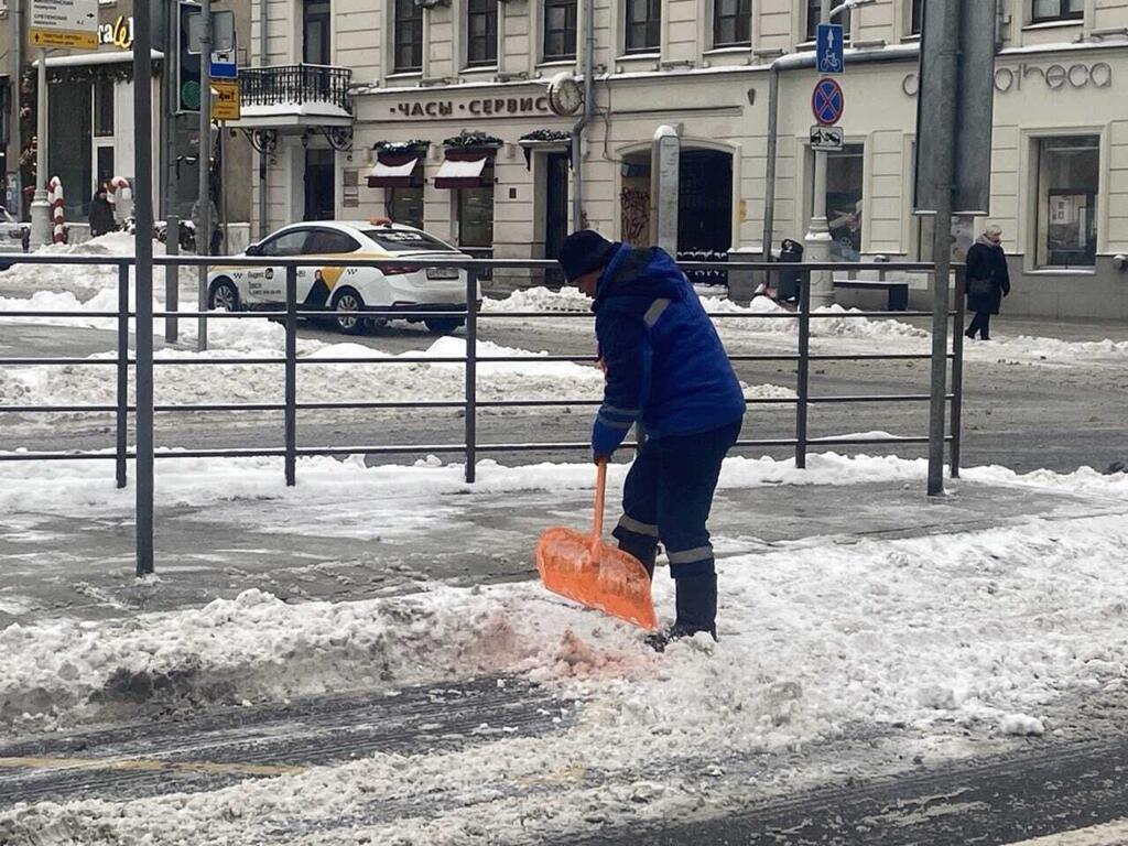 Un migrant qui déneige dans les rues de Moscou.