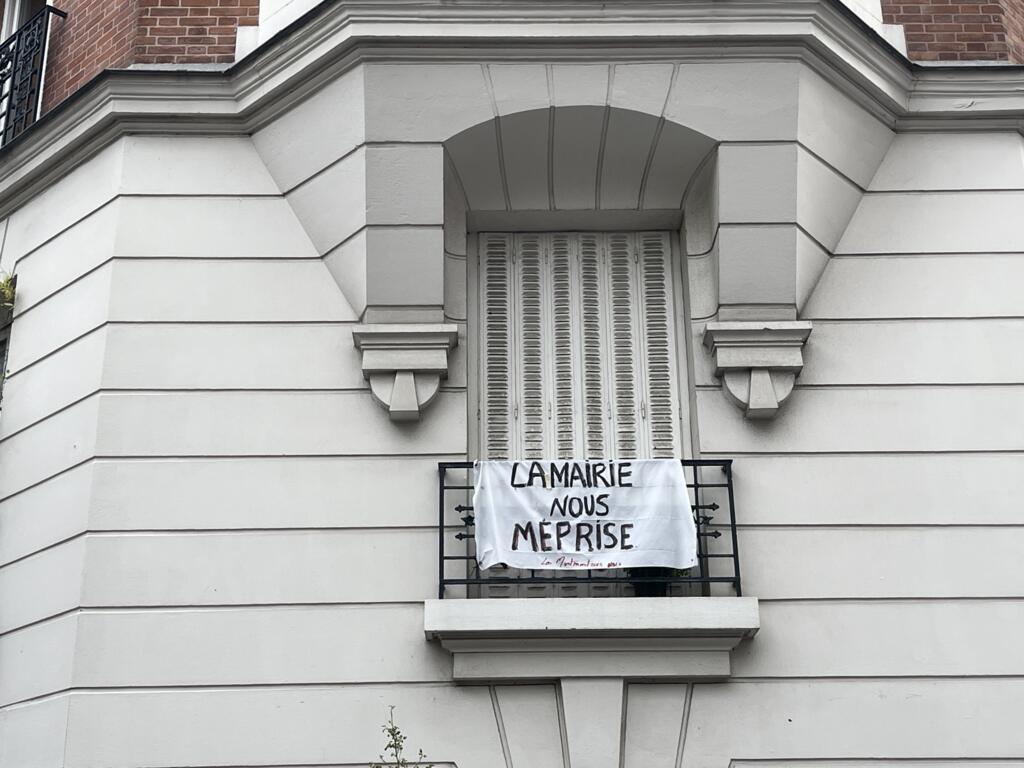 Faixa em um edifício de Montmartre, onde moradores dizem se sentir "desprezados pela prefeitura". O bairro está passando por um processo de transformação de ruas em áreas exclusivas para pedestres. Em 24 de julho de 2025.