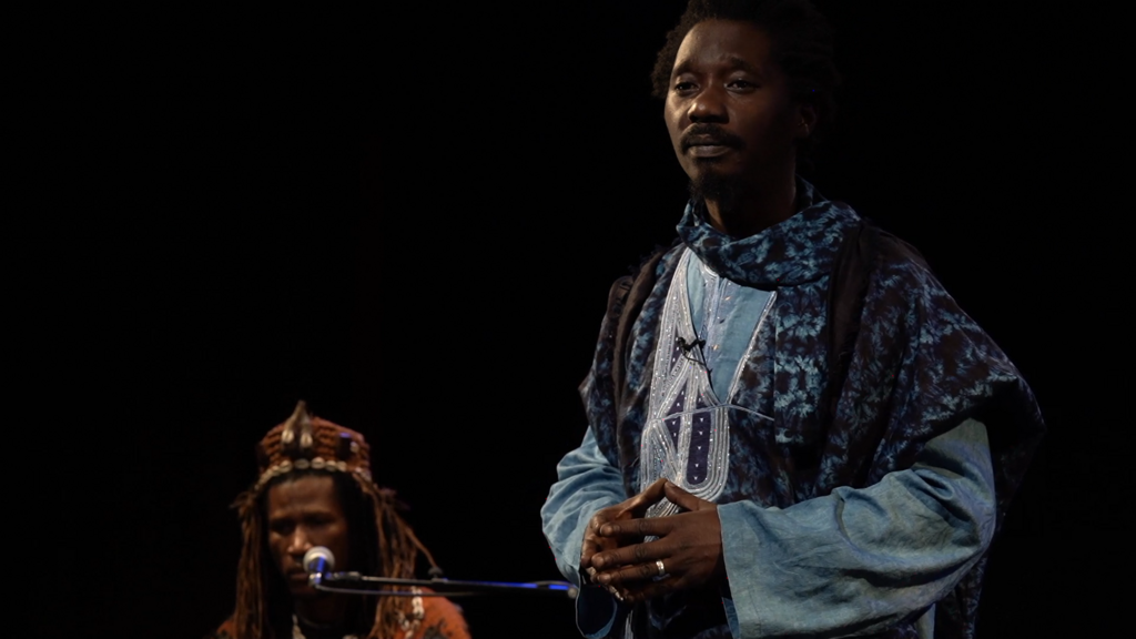 Le comédien Kader Lassina Touré joue Modibo Keïta sur la scène du Théâtre des indépendances, accompagné par Abou Diarra au n’goni.
