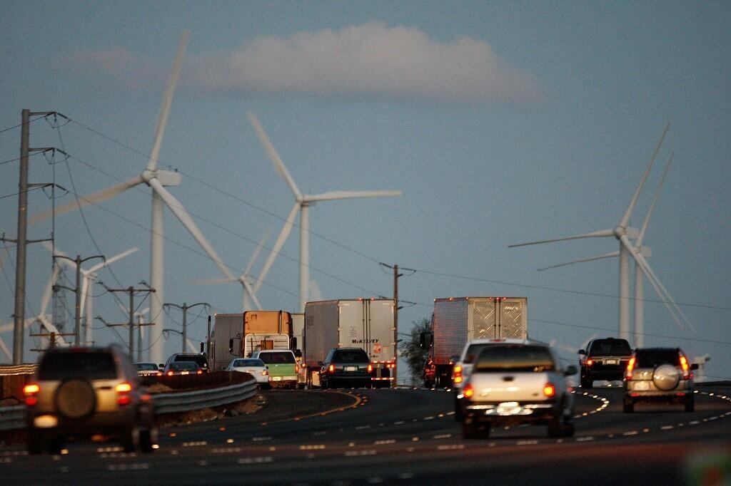 Emissions-producing diesel trucks and cars pass non-polluting windmills along the 10 freeway near Banning, California. (Illustration photo)