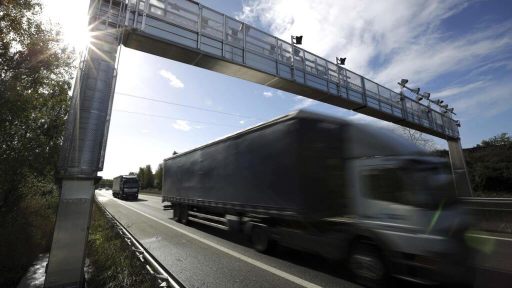 En France, un camion passe sous un portique de contrôle de l'écotaxe à Saint-Sébastien-sur-Loire, près de Nantes, le 29 octobre 2013.