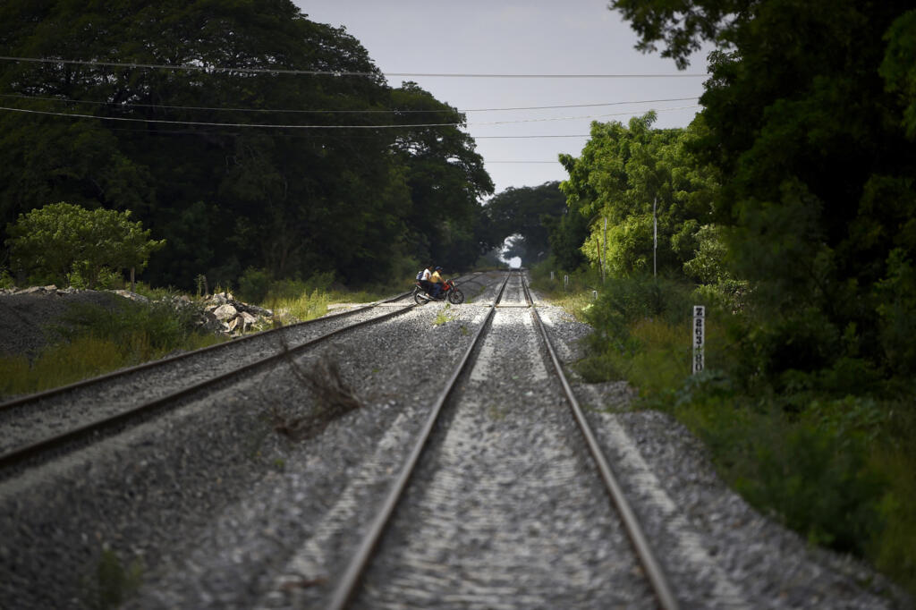 Des habitants traversent les voies ferrées à moto pendant les travaux d'expansion du chemin de fer interocéanique qui relie l'océan Pacifique et le golfe du Mexique, à Ixtepec, Oaxaca, Mexique, le 10 octobre 2023.