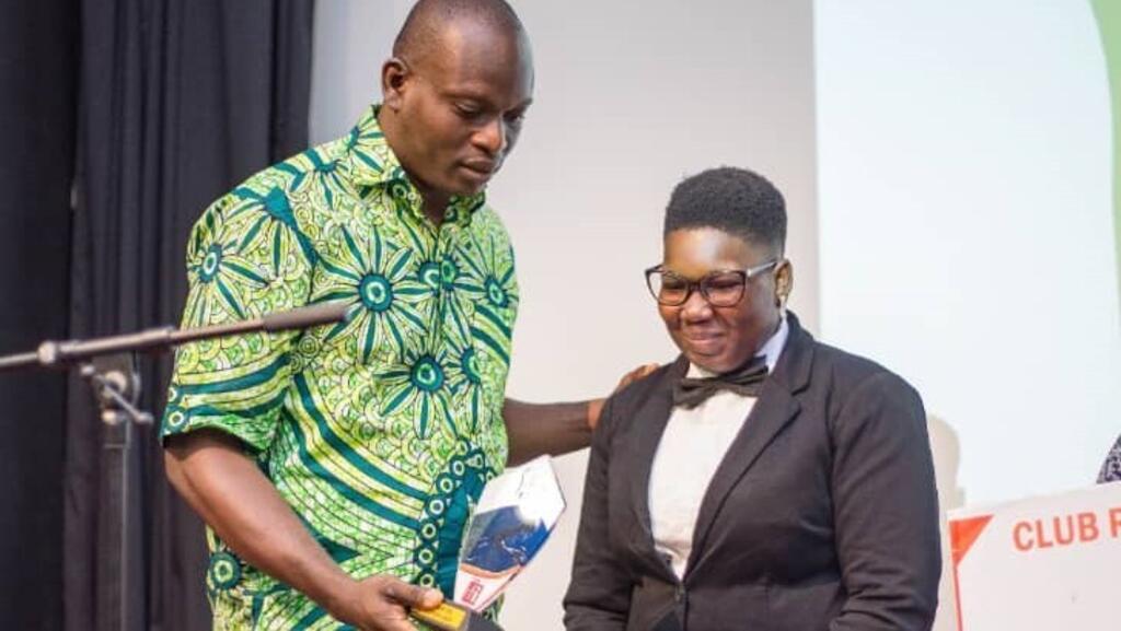 Remise du trophée à la lauréate Rosalie  Kounouhou par Moucharaf Sadikou, président du Club RFI Cotonou.