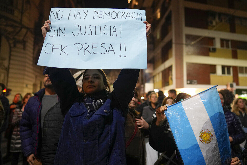 Uma mulher mostra um cartaz com os dizeres "Não há democracia sem justiça, CFK (Cristina Fernandez de Kirchner) presa", em frente à casa casa da vice-presidente argentina, em Buenos Aires, em 22 de agosto de 2022.