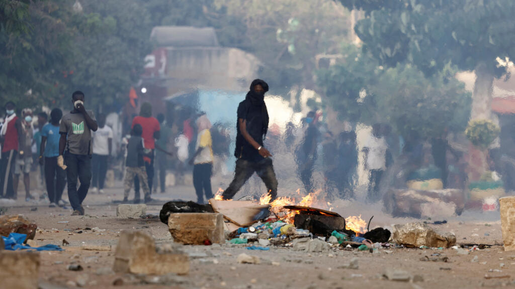 
Un partisan du chef de l'opposition sénégalaise Ousmane Sonko marche près d'une barricade en feu lors d'affrontements avec les forces de sécurité après la condamnation de Sonko à la prison, à Dakar, Sénégal, le 3 juin 2023.