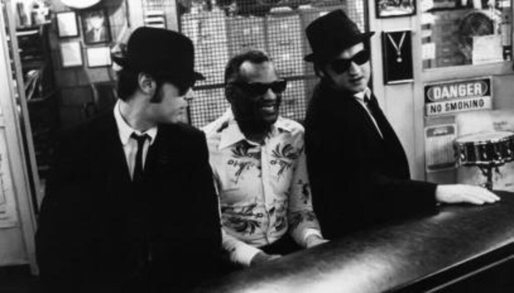 Dan Aykroyd (gauche) et John Belushi (droite) écoutent Ray Charles jouer du piano, scène du film "The Blues Brothers", 1980.