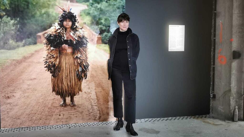 A artista brasileira Lívia Melzi em frente a uma das imagens da exposição Tupi or not Tupi, em cartaz no Palais de Tokyo, em Paris, em 18 de outubro de 2022.