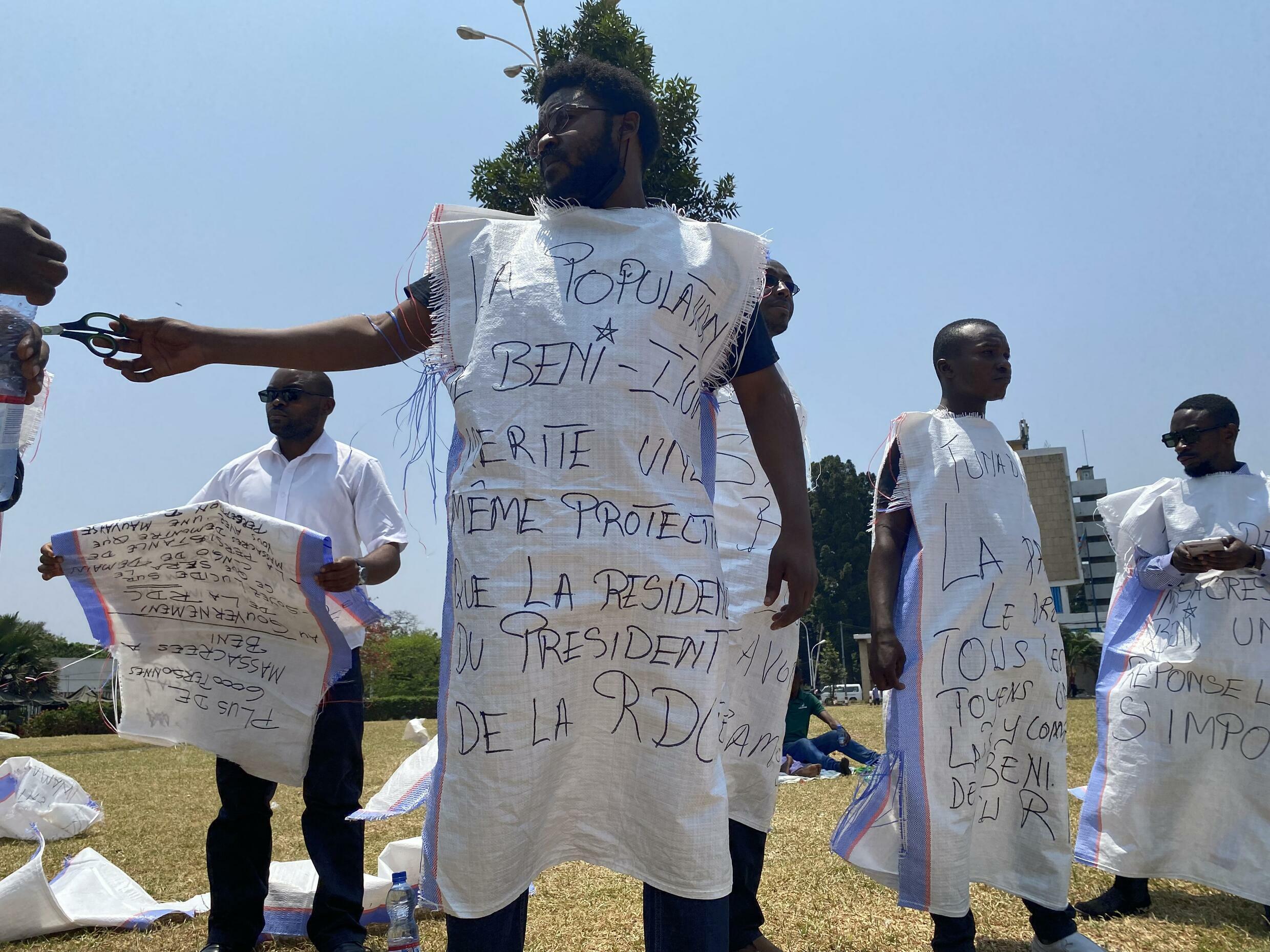 Des jeunes ressortissants de Beni enfilent des sacs avant de déposer un mémorandum à la présidence, le 13 septembre 2021 à Kinshasa en République du Congo.