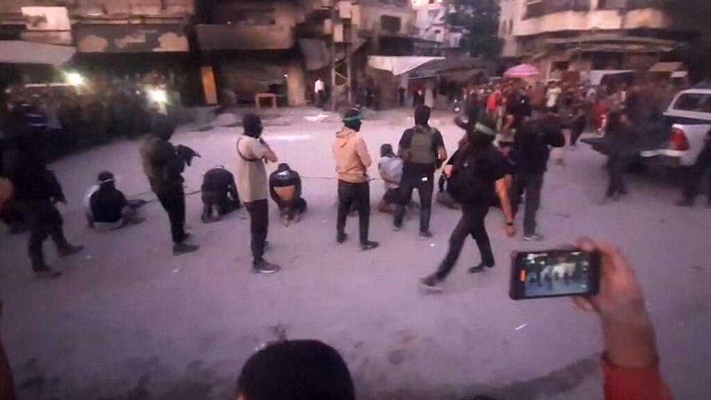 Cette image extraite d'une vidéo publiée par la chaîne Telegram de la télévision al-Aqsa, gérée par le Hamas, le 13 octobre 2025, montre des combattants armés du Hamas se tenant derrière des hommes aux yeux bandés, ligotés et agenouillés alors qu'une foule les entoure dans une rue de la ville de Gaza. Le groupe militant du Hamas a publié une vidéo en ligne montrant ses combattants exécutant huit hommes aux yeux bandés, ligotés et agenouillés dans la rue.
