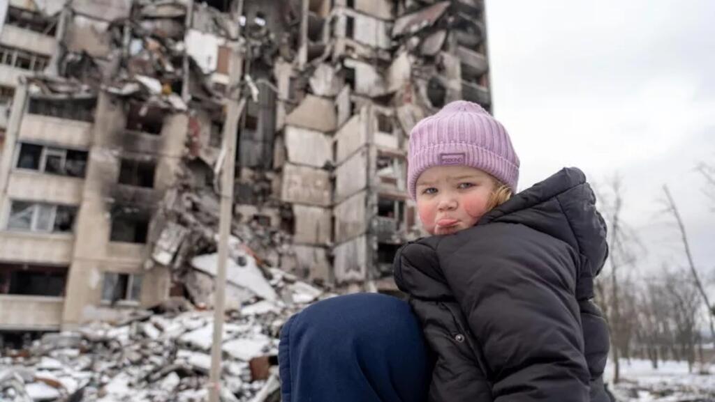 O fetiță de doi ani în fața blocului în care locuia, după un bombardament rusesc, Saltivka, Ucraina, februarie 2023