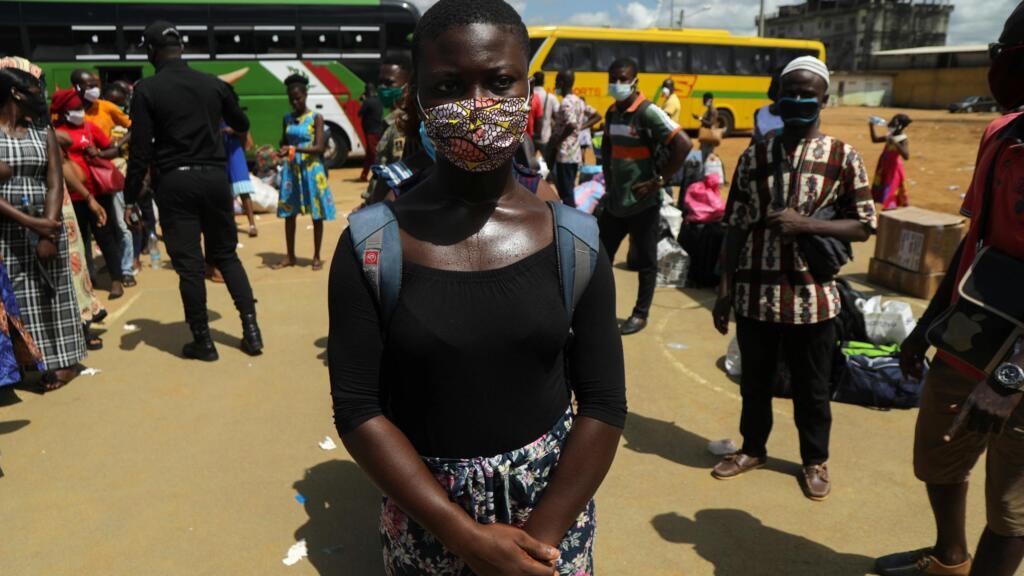 Une étudiante ivoirienne attend un bus pour retourner à l'école à la suite de l'allègement des mesures de confinement, le 19 mai 2020 (image d'illustration).