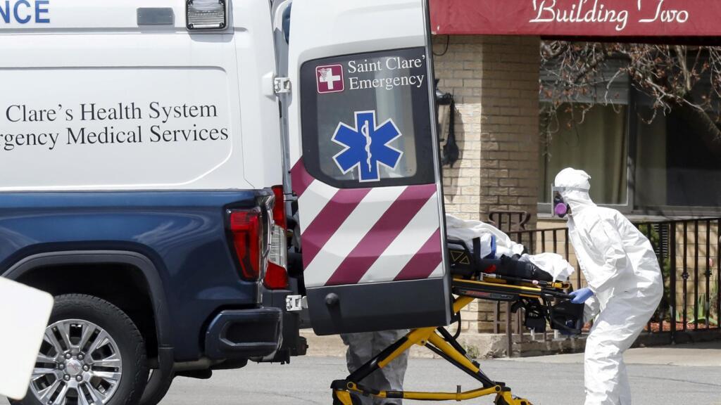 Du personnel paramédical charge un patient dans une ambulance au centre de soins d'Andover, lors de l'épidémie de coronavirus, à Andover, New Jersey, États-Unis, le 16 avril 2020.