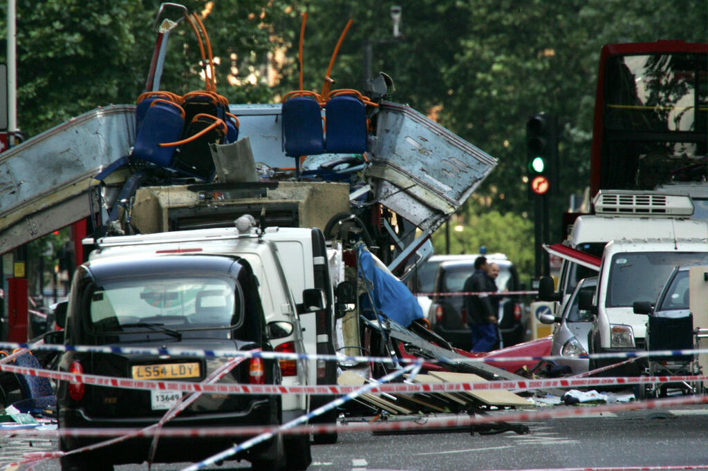 Cette photo d'archives du 7 juillet 2005, montre l'épave d'un bus à impériale, le toit arraché par une bombe, et des voitures endommagées éparpillées sur la chaussée de Tavistock Square, dans le centre de Londres.
