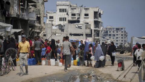 Dans la chaleur estivale, des Palestiniens font la queue pour aller chercher de l’eau à un point de distribution de la ville de Gaza, le mardi 12 août 2025. [Image d'illustration]