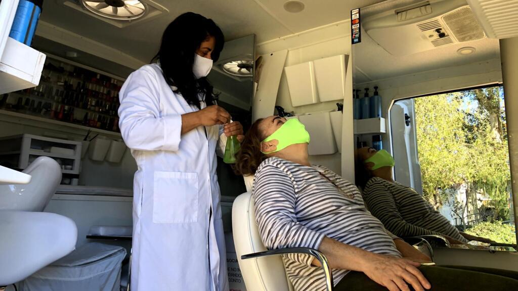 A cabeleireira Cláudia Moreno durante atendimento em sua van adaptada para serviços de beleza.