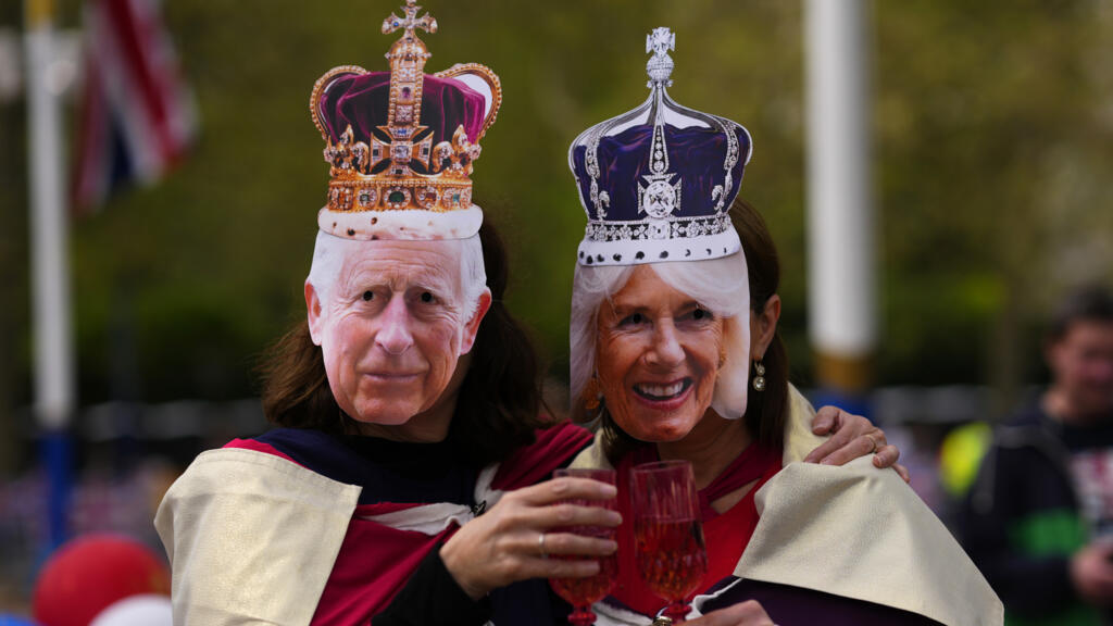 Deux personnes portant des masques du roi Charles III et Camilla, la reine consort, à Londres, le vendredi 5 mai 2023. Le roi Charles III sera couronné à l'abbaye de Westminster le samedi 6 mai.