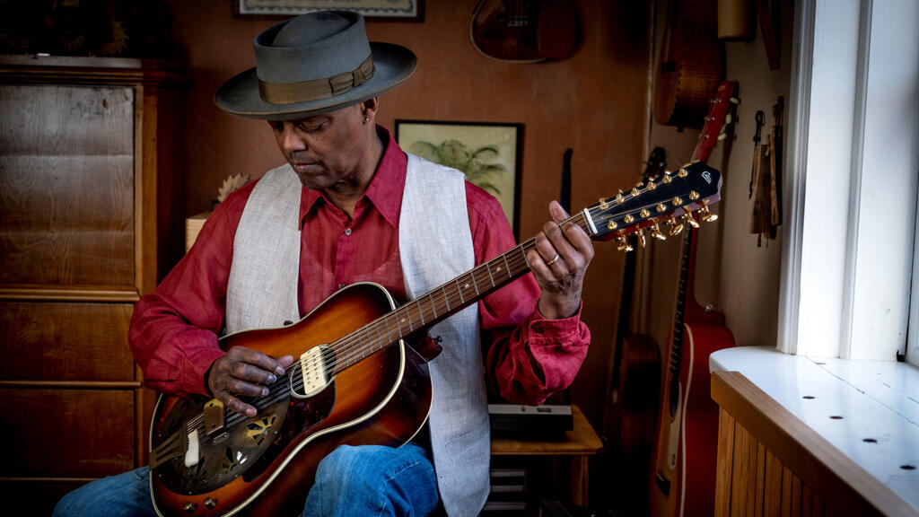 Eric Bibb répète, chez lui, ses nouvelles compositions.