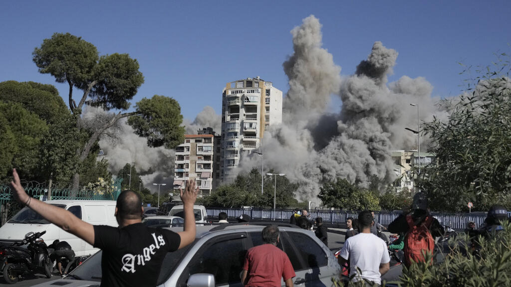 Les gens réagissent alors que de la fumée s'élève d'un bâtiment touché par un missile israélien à Ghobeiri, Beyrouth, Liban, le mardi 22 octobre 2024.