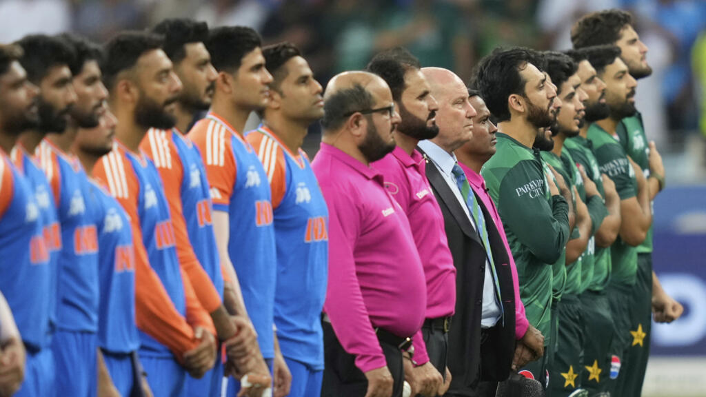 Les joueurs pakistanais et indiens se lèvent pour l'hymne national avant le début du match de cricket de la Coupe d'Asie entre l'Inde et le Pakistan au stade international de cricket de Dubaï, aux Émirats arabes unis, le dimanche 21 septembre 2025.