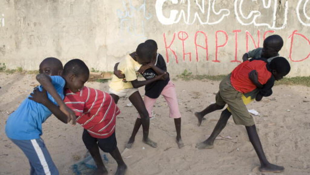 Des jeunes garçons pratiquent la lutte traditionnelle dans une rue de Kaolack, au Sénégal.