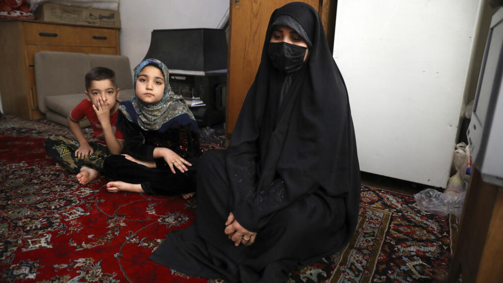 Zahra Husseini, réfugiée afghane, et ses enfants, Salehe, au centre, et Shahrzad sont assis dans leur chambre dans une banlieue pauvre de Téhéran, en Iran, le 21 avril 2022. Les talibans, qui ont tué son mari militant, ont proposé un marché à Zahra Husseini : Épousez l'un d'entre nous et vous serez en sécurité. Zahra Husseini, 31 ans, a alors décidé de fuir en Iran.