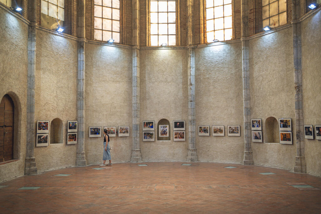 Une femme regarde des photographies de l'exposition « Grandir dans la cour d'écrans » de Jérôme Gence lors de la 36e édition du festival de photographie de presse « Visa pour l'image » à Perpignan, dans le sud-ouest de la France, le 28 août 2024.