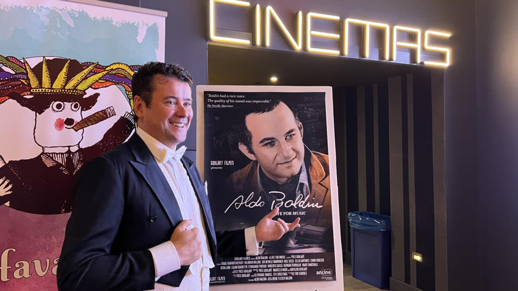 O diretor Yves Goulart ao lado do cartaz do filme “Aldo Baldin – Uma Vida pela Música”, que já recebeu 24 prêmios em festivais pelo mundo.