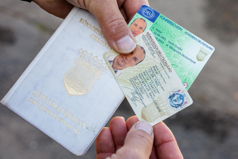 Peter Fitzek, o autoproclamado chefe do chamado “Reino da Alemanha” (Koenigreich Deutschland), mostra documentos de identidade de "realeza" feitos por ele mesmo, em Wittenberg, no leste da Alemanha, em 23 de outubro de 2023.