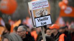 Une pancarte en forme de boîte de cigarettes avec le slogan « vieillir tue », lors de la manifestation parisienne au cinquième jour de mobilisation pour les retraites, ce jeudi 16 février 2023.