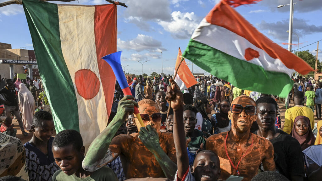 Apoiadores do Conselho Nacional de Salvaguarda da Pátria (CNSP) do Níger em frente ao Níger e à base aérea francesa em Niamey, em setembro de 2023, enquanto manifestantes se reúnem para exigir a saída do exército francês do Níger.