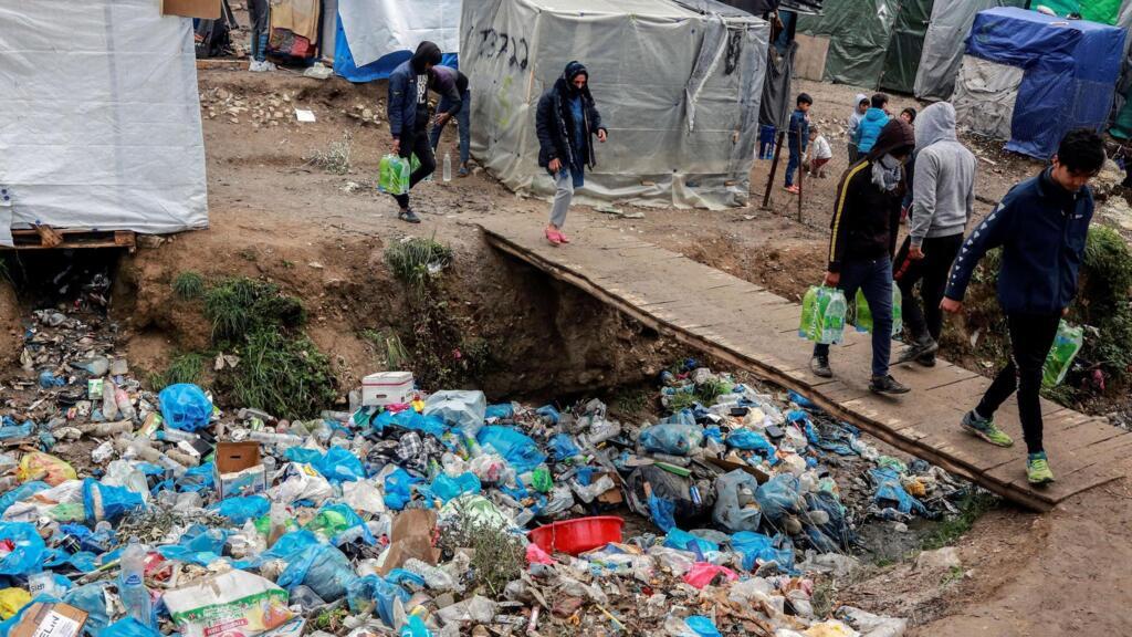 Des migrants circulent au milieu des détritus dans le camp de Moria sur l'île de Lesbos, le 2 avril 2020.