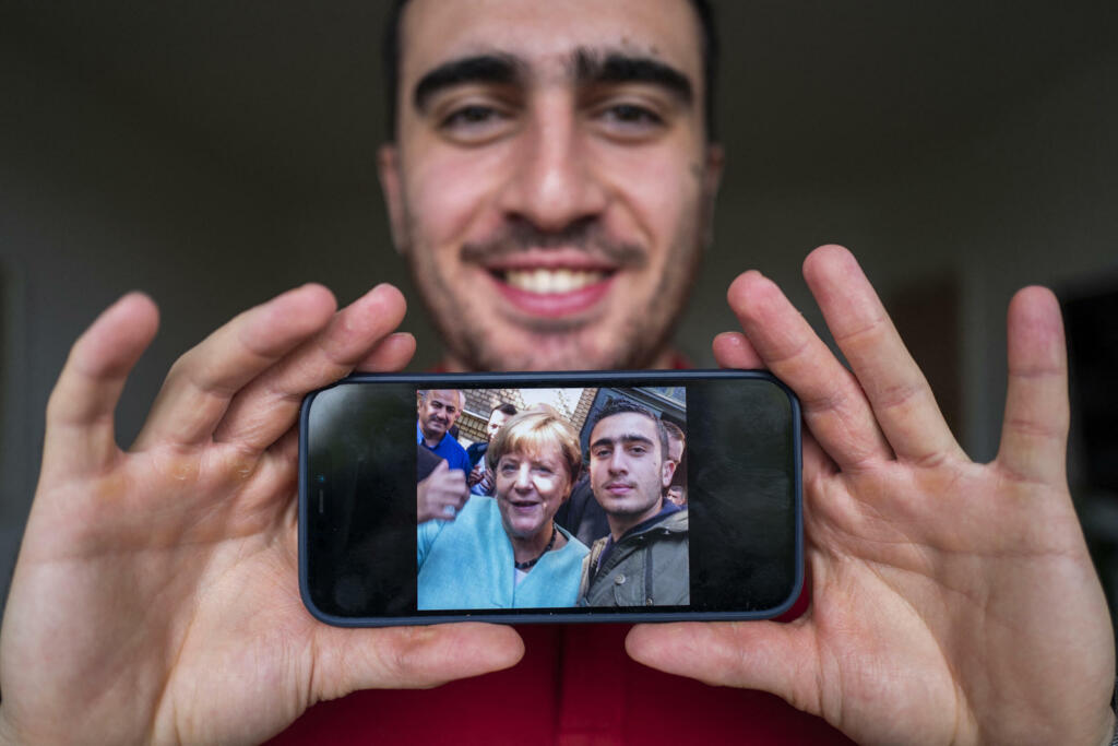 Anas Modamani est un réfugié Syrien qui vit à Berlin. Il montre un selfie qu'il a pris avec la chancelière allemande Angela Merkel devant un centre de réfugiés à Berlin, le 10 septembre 2015, alors qu'il avait 18 ans.