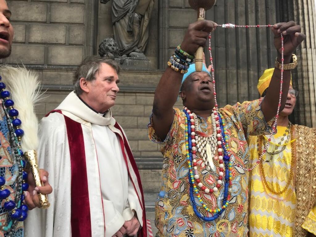 O babalorixá Pai Pote entrega uma conta de Xangô (deus da Justiça) ao padre McCarthy durante a Lavagem da Madeleine de 2019. 
