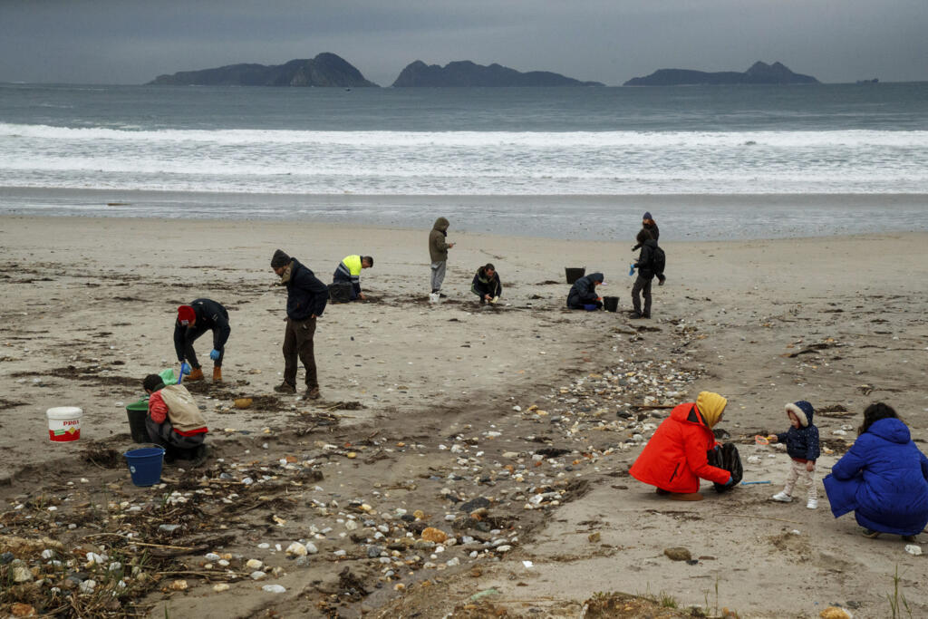 Des bénévoles collectent des granulés de plastique sur une plage de Nigran, Pontevedra, Espagne, le mardi 9 janvier 2024.