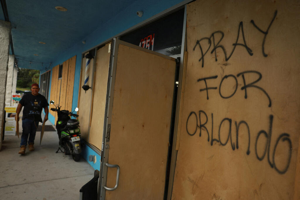 "Rezem por Orlando", diz frase em madeira colocada para proteger fachada de loja antes da chegada do furacão Milton em Orlando, na Flória (8/10/24).