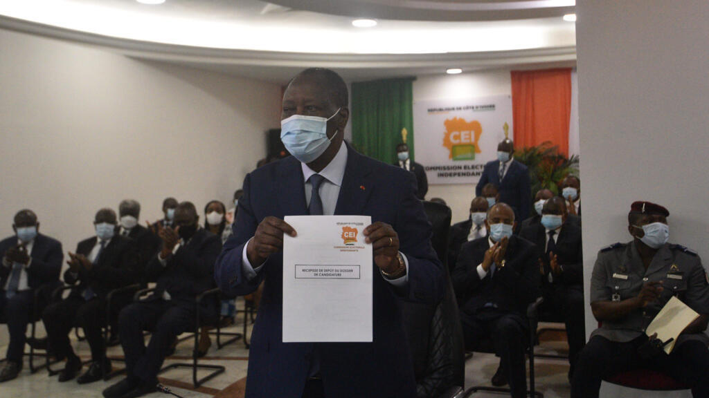 Le président ivoirien Alassane Ouattara montre son formulaire de candidature lors de la présentation de sa candidature à la présidence des prochaines élections, au siège de la CEI à Abidjan, le 24 août 2020.